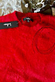 I was so excited to receive this sweater, and love the rich red color, but it arrived damaged (see photo--the material is thinning in the top left corner and gives it the appearance of having a black stain). It is also very very short (and I am not tall and have a shorter torso).  For the price, I expected better quality. Unfortunately, I had to return it. :( - Sandra W.