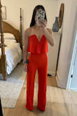 I originally ordered an XS (as pictured) and decided to size up to a small. Even though the small is a little big in the midsection and I will have to have it hemmed, I liked how the top came up higher to cover more of my chest and it was easier for me to zip by myself in a bigger size. This is a fun bright color and the material is very smooth. I bought this jumpsuit to wear to Vegas. - SaraAnn G.
