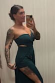This stunning jumpsuit features a vibrant emerald green color that is sure to turn heads. The strapless design adds a touch of elegance, while the cutout detailing on the sides adds a hint of sexiness. The wide-leg silhouette gives the jumpsuit a chic and modern look, making it suitable for any occasion. Whether you're attending a formal event or a night out with friends, this jumpsuit will make you stand out and make a statement. Its comfortable and flattering fit makes it a must-have for every fashionista. Pair it with heels and statement jewelry for a complete and stylish look. - Melisa H.