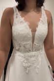 This dress is so beautiful. Great quality, and fits my body so well. The only major alteration needed is the length. I'm 5'5 and I'll have to take off about 3 inches. The bodice is so simple and elegant. The plunge is not very deep and the back is the perfect dip. It does have a bit of a train (1-2 feet behind). The hidden zipper is located down the butt and you can see it a little (pictured) but doesn't bother me. VERY happy with getting my dress online for a reasonable price as opposed to shopping at boutiques all day and spending over $1,000 for a 1-night dress. - Chelsea K.
