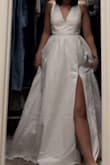 This was a return for me, but only because it didn't flatter my body or match the vibe of my event (wedding). Upon seeing the dress, the bow, leg slit, and the low back was my favorite thing about this dress, but everything else didn't work out for me. There was too much tule for my liking and it was very noisy when walking. The bow is detachable (by two simple buttons) and considerably lighter when removed. It was very easy to remove which made me nervous. The slit was... How do you say? "Not giving." I am smaller chested and the top of the dress was a little large, but not large enough that I should size down. The straps are adjustable, but not totally. The strap widens as it gets to the top of the shoulder, so it makes the straps look odd as the adjustable piece gets closer to the top. I saw the other reviews and they looked lovely and beautiful. It just didn't work out for me. - Chelsea K.
