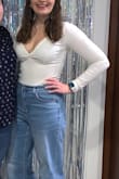 I am absolutely obsessed with this top and have it in the purple color too! It is so flattering, but definitely plan on some body tape or wearing a lacey bandeau underneath because it is quite chesty. I love that it's a bodysuit so it doesn't budge at all and is more of a thing cut so no panty lines either! 10/10 would recommend! - Samantha N.