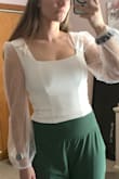 The body is a thick material that's not see-through. Very pretty square neckline. The sleeves are beautiful with the tiny pearl details. Perfect bachelorette party option! - Dakota B.