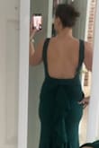 I bought this dress for attending a winter wedding. The material is high quality and thick with a liner. The green is so dark that the color is hard to appreciate in some lighting. There's no zipper and I had to put it on overhead which meant wearing it while doing hair and makeup. All the drama is from behind so it can feel plain by front view but I did get multiple enthusiastic compliments at the wedding! I'd love to see it made in another color too. - Carrie V.