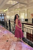 I wore this to a wedding and I sized up to a medium (my reg size is small) and it fit my 30-week belly. I did have to get the top of the chest altered so those with bigger breasts may fill it better! - Kailin V.
