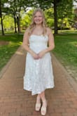 The material is not stretchy but I got the true to fit size the site recommended. I got it for graduation and graduation pictures. The flowers are so detailed and pretty in real life! - Lauren C.