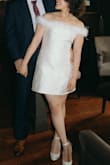 This dress is such a fun look! I wore it for my engagement pictures and it fit perfectly with the vibe. It looks more flattering if it's snugger at the waist, so I had to take it to a tailor to take it in (pictures are after it being tailored, so I recommend sizing down if you want it to look similarly). Also, the feather lining came loose from the back immediately after putting it on, but I just tugged it into the dress from the back and it was fine. The parts where the feathers are sewn into the dress is also extremely itchy, but if you're able to put it out of your mind, it's fine. I was willing to sacrifice my comfort for the look lol. It looks stark white in the picture here and any other pictures you take of it, but it's actually ivory in person. - Elisabet L.