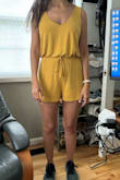 I kept this romper because it's a soft and easy one-piece, and you can wear a regular bra without an issue. BUT it's mustard not yellow and VERY short to the point that I will probably only wear it around the house and to work out and also because the material is thin and shows any imperfection and cellulite. Also, the proportions of the top, in relation to the bottom, are off. I think the pic shows that. I hope Lulus can make something similar with the yellow color, as actually depicted, in a thicker cotton and longer design. Most of their rompers are too short but super stylish. - Marline K.