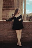 I purchased this dress for a photoshoot in Rome. Love the flowy fit, long sleeves, and the open back! It's not too short, but be careful raising your arms over your head. The only downside is that the sleeves fall off the shoulders. Make sure to secure it with fashion tape. - Olga P.