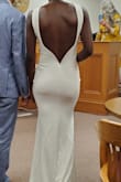 This dress fit me perfectly. I got just my regular size(4), and I didn't need to have any alterations. It feels like a heavier material, has a lining, and feels very drapey and comfortable. I could literally sleep in it. The back has a boning effect to stay in place with the low scoop back thingy. I wore it for my courthouse wedding and literally got tons of compliments from strangers while we were walking the street downtown to and from the courthouse to the restaurant. It's very well made!! 10/10 buy this dress. Elegant and simple, but playful, in the back - Justina K.