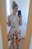 The dress arrived so quickly and I was able to track it the whole way which was wonderful. I was excited to try the dress on and have already planned a variety of occasions I will be wearing it. The zip and hooks at the base of the back are tight enough that there is no gapping but not uncomfortable. The flowers are all individually attached and look so stunning, the skirt is full so doesn't fall flat and creates a really pretty shape. I cannot wait to wear it out! - Amy K.