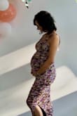 I loved this dress for my baby shower! I'm pretty small, 5' 4", 105 lbs when not pregnant. At my shower, I was 32 weeks and ended up wearing an XS. I could've fit into the small, but the straps were kinda long. I wanted it more fitted...to show off the bump :) What I didn't do was walk around in it before the shower; it's pretty fitted down thru the legs so I had to take "baby steps" all day, which is fitting :D Besides that, it fits great and was nice & stretchy. - Mel R.