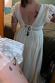 I ordered this for my elopement and it's very pretty! I'm between M and L, but after reading reviews, sized down to M and am glad I did. The shoulders are soooooo roomy despite usually filling out a dress with DDs. It's also pretty long for a midi (even with heels). Given how much the shoulders and length need to altered along with the delicate overlay, alterations ended up being about 3x more than what I bought the dress for, but it's still more affordable than an actual wedding dress and I definitely don't regret it! 

P.S. You'll also want some boob tape and double-sided fashion tape to hold everything in place! - Lauren L.