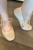 Looks super cute/fit the ballet-core aesthetic. Decently roomy toe box. A tiny bit lighter pink than in the photos. Definitely pink not peach. Look well-padded in the photos, but it's not actually memory foam; it's a very thin squishy layer? They don't really feel padded at all. [They're] flats, so I was not expecting arch support, but they're so flat/flexible that the heel is the only rigid part. It feels a bit odd to step (like the heel hits the ground first? I'm sure, if I walked over rocks, I could feel them through the shoes. The tie is some kind of squishy material similar to the outsole of the shoe. Seems sturdy enough. I think this shoe would be a good fit for an office job or non-walking/non-outdoor activities. True to size and I'm a 7 flat, 7 1/2 heels. - Brooklyn Y.