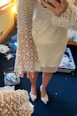 I love this dress! It's so beautiful in person with the pearls and beads. It was very large though, especially in the arms. It hung on me and the sleeves were past my hands. Going to try a different size and see if that works! - Hannah H.