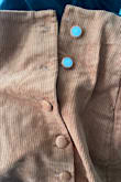 The top two buttons popped off the first time I tried it on. - Kara H.