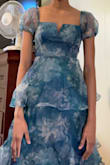 The material yes is organza, but this felt a bit on the cheap side. The zipper as others said is wonky; I was afraid of breaking it. It's a bit itchy so beware of that. Not as expensive looking or bright as the picture. It's worth half the price. I'd buy it for $30. The V cut will bend and be hard to fix so be careful when taking off! Some positives: I did love the square cut and the puff sleeves. The layered look was cute too. It photographs very well. Looks better in pictures than in real life so that was a plus. Returning though! Got an XS which was a BIG mistake. Could barely breathe. Should've gone with a S - runs very small! - Taylor-Dayne D.