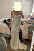 I ordered this for my wedding/elopement ceremony, and it is just as shown in the images! Very heavy material, and the dress has a liner underneath the main satin. Still pretty see-through, even with the liner. Dress is a little short in the front, so when I wear heels with it my toes barely peek out from the front- something to keep in mind! The color appears more yellowy in my photos, but in person, it definitely looks more like an off-white/ivory color. Definitely a more low-cut top, but when I tried it without a bra, it worked perfectly and didn't make me feel like I was showing too much. Overall great quality, and a beautiful train! - Mary M.