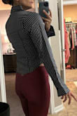 This is a very cute shirt and it does look like the one pictured in the photos. The thing is that it is a tight fit, the light fabric does not have any give, and I would highly recommend sizing up; also be aware that it is more of a cropped fit, so if you want this for work, you're likely gonna have to wear high waisted pants with it, but it will look really good if you have a lean hourglass figure. It looks good on me and I'll be keeping it, but I have a lean athletic hourglass build with a smaller chest, so take that into account as well. - Carley J.