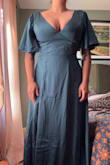 This dress is really pretty. The quality of the material is surprisingly good. It's much thicker than a lot of the satin style dresses I've tried on recently. It is very long. If I would have kept it, I would have had it shortened significantly. Overall, it was a very nice dress, but I didn't love it enough to invest in altering it. It's a little overwhelming on my petite frame. The pics show what a large chest, no bra looks like. - Briana R.