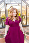 I ordered this dress in burgundy for my engagement shoot and it was perfect! The wrap creates a flattering shape and allows your leg to peak through a little when walking, but nothing crazy. The slit in the sleeves is not too noticeable and adds a bit of flare to the dress. Getting the dress on was a little difficult because of the way it ties, but it does have a snap on the chest to keep your boobs from flying out. It's a little bit sheer, but theres a small slip that covers from your waist to thighs underneath. The length was perfect with a small heel! I would totally recommend! (The color of the dress in the photos are slightly off due to the filter, in person it is a true burgundy.) - Sarah L.