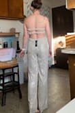 This is so pretty. I ordered a S, and it fits pretty well. I actually liked the boning in the sides as it helps the top stay up better than other strapless jumpsuits I've tried. It is overall a warmer silver, though the sequins themselves are straight silver. The stretchy straps across the back are really comfortable. I am on tippy toes in the picture, so if I keep this I will definitely have to take the hem up several inches as I don't wear super high heels. Overall really nice jumpsuit. It's lined all the way to the bottom so neutral colored underwear shouldn't show through too much if at all. - Sarah O.