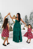 This dress was the perfect shade of emerald green for my family's Christmas photos! I love the scalloped shoulder detail and the quality of the material.

I ordered a medium, but the bust was too large, so I had it altered. The tiered material below was also a bit baggy, so next time, I'll order a small. - Danielle L.