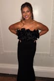 The material is stretchy! Top stayed up great and I wasn't pulling at it during the event. Did not need to wear a bra because of the ruffles. 
I have a petite athletic build and this dress fit like a glove! Snug but not too tight! True to size. The slit in the back adds a little fun without being too revealing. - Elizabeth W.