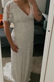 The dress fits perfect! I love the train and the detail. I was able to zip the dress up on my own! I got a size large. - Faith N.