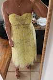 Let me start off by saying this dress is GORGEOUS. The color, the fabric, the fit, everything is beautiful. I've never worn yellow in my entire life, but this specific shade is absolutely beautiful. Definitely brighter than the pictures make it seem. I ordered an XL (34" waist, 38DD bust, 5'9", 210ish lbs) and it fits great. It's a bit snug, but I wouldn't size up. I can't fasten the metal hook by myself, but I was able to zip it up with no issues. My biggest complaint is the yellow slip underneath is very see through. You can see my nude colored Spanx, even through the mesh lining on top. It's not HORRIBLY noticeable, but I would be self-conscious about it, so I will be taking it somewhere to have an additional slip added to it. Also, I wore it around the house for 30ish minutes and was definitely readjusting the top frequently, but it's strapless and that's to be expected when you're larger chested like me. All in all, super happy I found this dress. I would order other colors in a heartbeat if they had them! - Sydney E.