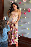 I was nervous because the fabric is listed as not having a ton of give. I was 36 weeks pregnant at the time of my baby shower (9 months!), and it fit perfectly in all the right places. I was so happy. Got so many compliments, it really is stunning on, the pictures don't do it justice. Felt like I was in a custom couture dress lol. I sized up from my normal pre-pregnancy size (S), I'm petite, and the bump is pretty poked out in the front. The fabric and style in the front worked really well to accentuate my bump without having to tuck a hand under, so it doesn't look frumpy. A hand under the belly was cute too, and because it was maxi length on me, it didn't ride up too high over my ankles. No regrets buying this dress, very quality and no complaints at all. - Amelia R.