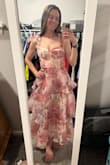 This dress is flirty and fun. The top fits close to your body but it's loose right around the waist and down. The shoulder straps tie into bows and you can choose how tight to make them. I purchased the medium and it fit very well. I couldn't wear any sort of bra with this, but there is some existing support without one. I did end up choosing another dress in its place that was less frilly but it was definitely hard to return this! - Jordan L.