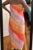 Lightweight, easy breezy dress! True to size. I have a tummy so I ordered a size up and it fits just right for my liking. If you want it more form fitting in the top, then order true to size. It has some stretch and the strapless part actually stays put. I'm 5'6 with long legs and it hits a few inches above my ankle which I think is very flattering. Highly recommend. - Sabrina D.