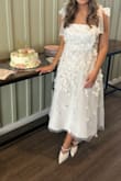 Got soooo many compliments on it at my bridal shower. It definitely fits tight for a Medium, and there is no give/stretch, but wouldn't size up any more - Courtney M.