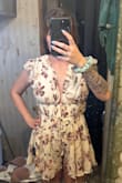 I love this romper, it looks like a dress, it's just creasing into my legs in this picture. It does ride up your privates a little. I can see how the sleeves can fall a little after walking around the house and just taking out the trash. Mine came with grippy strips on the inside that do help if the sleeves are pulled up closer to your neck, like in the pic. So they are trying to help with that situation. It's not cheap polyester either, feels nice. - Nicole S.