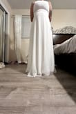 The dress is sewn very unevenly at the bottom. One side hits the floor and the other is perfect length. The back sheer part of the dress comes up above the slip portion of the dress. - Kayla K.