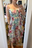 This is really a lovely dress. The sweetheart neckline and ties at the shoulders are so pretty. Though the ruffles are more than I'd normally wear, I love them so much! I also appreciate the lace up back that allows me to wear it as tight or loose as I need for comfort. The colors are bright and fun and perfect for a summer wedding. - Annie B.