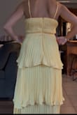 I wanted to love this dress so much. I bought to wear to a rehearsal dinner in July. It is an inch too high on either side in the bust even with a heavily padded bra. I am small chested, but it would fit DD. The pleating on the dress was also not even. One side was longer on both the bottom layers. The backing was also not sewed in even. One side was not pulled tight enough when sewn together. Both photos are taken after I took in 1.5 inches on both sides in the rib cadge. You can still see how the back right section has more fabric than the left. You can also see the middle layer  is longer on the left side. The bottom layer looks the same. Over all very sad the dress was made poorly & I would have retuned but I'm not willing to risk another dress looking like this or not getting here in time. - Taryn B.