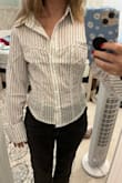 The material and print of this shirt are great, and I love that it has more of a cropped look since I'm 4'11 and most dress shirts end up looking more like dresses on me. The only things that are slightly bothersome are the looseness in the chest area and the very long sleeves. The shirt is actually somewhat tight around my stomach, and I would size up if it weren't for the comparably larger chest and arm areas.
Overall: it's a cute shirt and I'm going to keep it, but it fits differently than I expected. - Jessie G.