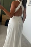 The color is white white vs. a soft white or ivory. The neckline and top part of the dress is very flattering but the bottom part is very bland, straight cut, no slit, back opening or anything. So the way it falls wasn't my favorite. Otherwise, beautiful dress - Karla T.