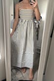 Bought this to wear to a friend's baby shower and was very pleased! I will say, the dress is much more lightweight than I anticipated and it is unlined. The fabric has the same kind of stiffness as a poplin shirt but a softer feel to the fabric, so it stays well structured and keeps its shape throughout the day. The cream color with the blue is nice as opposed to a stark white, and I love that the skirt is fuller but also relatively flowy. Was a little difficult to pull over my head, but thankfully the bodice stretches nicely. I have a very small chest, but the top felt secure and the darts laid where they were supposed to, even without a bra! Overall a beautiful summer dress. - Stephanie S.