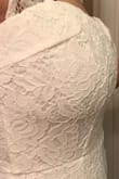 I bought this as a potential beach wedding dress. I didn't fall in love with it but it does look like pictures. The material is nice and stretchy. Ran about 3 inches long on me. It did show more cleavage than I would have liked, but not distasteful. Very pretty, bright white. My only complaint is the side bullet seams at the bust. They are not evenly placed and one bulged out due to them not cutting excess off or poor sewing. This is my first time buying from LuLus. Hopefully this was a fluke and not the typical quality of the dresses. I would consider the dress if the seams were fixed. - Kayla H.