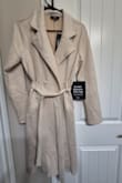 This trench is better in person. The texture of the fabric is like a micro-suede which doesn't show up in the pictures. The length is versatile, and the weight of the jacket is thin, but still gives warmth. This looks terrific with many outfits and especially snazzy with a dress. I usually wear a medium, but this runs large, so the small worked great for me. - Elizabeth E.