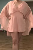 I really like this soft pink minidress. It's got a dreamy, sexy, 1970s vibe with a cape that extends past the dress. I plan to wear it for a birthday night out. The fabric is soft and crepe-y fabric. The fit is relaxed. The top is quite open so bear that in mind if you have a larger bust; it may be difficult to find the right bra to wear with the dress. Overall, I'm very happy with the dress! - Rachel L.