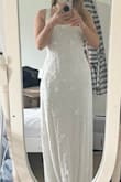 Bought this for my wedding. I went for a medium so I would have room for alterations, but it really only needs a tiny bit on the waist and the straps taking up. There's a lovely weight to the fabric, but it still feels light and wearable. The back isn't too low, so you could still wear a Skims bodysuit. - Iona B.
