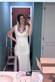 I like it, but I'm not sure I LOVE it. It's a nice dress for the price. The material is decent, has some weight to it without being hot and heavy and the back button details are beautiful. Im not a huge fan of the breast area and lack of support. Definitely need to sew in padding or find a supportive strapless bra. I'm 150 lbs and 5'8, usually go for a size 8 dress or large, but decided to get a medium and it does fit which is great! But the lower waist area is a little loose so I would have that altered to have a more fitted look. The fabric does have stretch to it. I was able to slip the dress on and do the zipper on my own which is a plus, too. Again, its not BAD. Maybe after alterations I'll feel a little more excited about it. I did add a bridal belt (not pictured) and it definitely pulled it together more, giving it more glam. - Amy C.