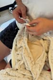 I bought this dress for my wedding in Costa Rica and brought it all the way there to wear on the big day. When I went to put it on, the zipper broke. I was completely panicked, and my husband was really upset too. Our wedding day was supposed to be special, and this added so much unexpected stress right before the ceremony. We had no choice but to try to fix it because there was no way I could find another dress just two hours before the wedding. My family rushed to a store and bought safety pins, and we had to pin the entire zipper closed, just to make it work. I'm including a photo of us trying to fix it. This was not the experience I expected for such an important day. - Khris S.