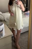 I ordered this dress for my bridal shower and LOVED it! The high neck was snug around my neck after I buttoned it, but that's just because I am not used to having anything remotely fitted on my neck! It just fit like a high neck would! But it was super flowy and had a slight ivory shade to it! I got so many compliments on it, and I can't wait to wear it again! - Leini E.
