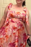I got this for a May wedding that I am attending and singing in. I actually thought this dress was as cute in person as it was online. I was worried about the light pink being too light, but it wasn't an issue at all. I typically wear an XL, and I'm not super busty, but I am proportional for my body. I found it to be too tight in the bust, causing weird shaped "ladies". A bra did not help because it made it even tighter. I would have sized up when I saw there's no give in the bust, but they were out of the XXL. The tie straps are cute, but I'm not sure how secure they are. I think if you get someone else to help, maybe double knot it, or secure with a hidden safety pin, it should be okay, but I struggled to do it on my own in a way that stayed put. It is VERY flattering in the midsection and flows away perfectly from any tummy you dont want to see. All in all, I must return it, but I am sad about it. It just isn't sitting right on my body. If you have even a slightly larger bust, I'd consider sizing up. - Heather B.