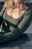This shirt is okay. The color and material are nice, but the fit is weird. The front is very low and wide on my shoulders. Makes it almost impossible to wear any bra. - Maddie S.